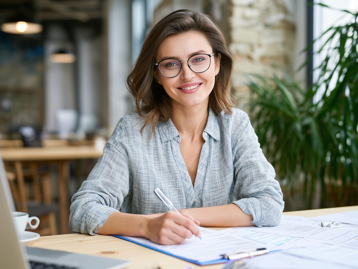 A business professional reviewing plans and paperwork at a desk
